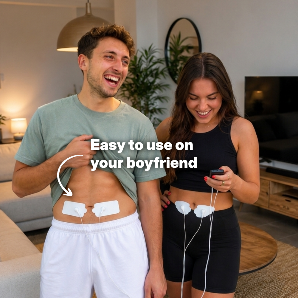 Woman controlling period cramp simulator connected to TENS pads on her smiling boyfriend's stomach