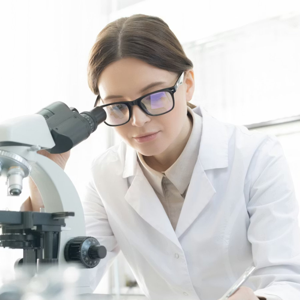 Female scientist in a lab coat using a microscope researching menstrual period pain